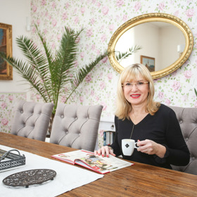 Moderátorka s kuchařkou, do které si vystřihává a zapisuje oblíbené recepty.