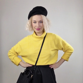 Žlutý svetr v kombinaci s černými doplňky.