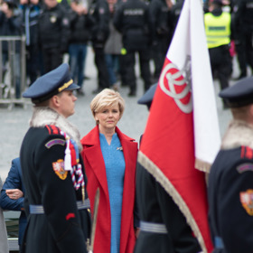 Eva Pavlová zvolila pro tuto příležitost červený kašmírový kabát a modré buklé šaty od české návrhářky Zuzany Kubíčkové.