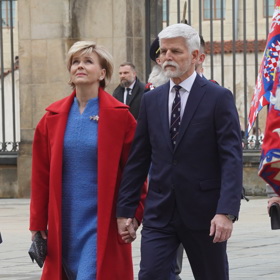 Manželka prezidenta Petra Pavla Eva oblékla během slavnostního dne hned dva outfity. První, ve kterém vyrazila už na oběd s končícím prezidentem Milošem Zemanem a jeho ženou Ivanou, tvořily modré buklé šaty couture od Zuzany Kubíčkové šité na míru. Kabát v červené barvě jemně odkazuje v kombinaci se šaty na české národní barvy.