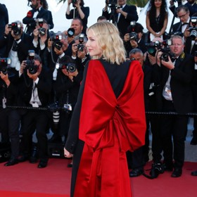 Cate Blanchett na filmovém festivalu v Cannes v roce 2018 v šatech Alexandra McQueena s rudou mašlí na zádech. 