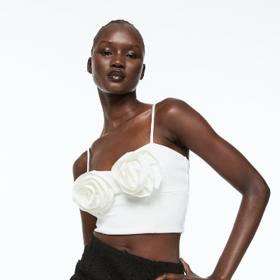 Crop topy patří k nejoblíbenějším. Nebojte se jejich krátké délky a noste je pod blejzr či bundu. Extravagantní variantu s aplikacemi najdete v nabídce H&M za 399 Kč.