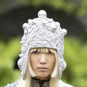 Napůl mikádo a napůl dlouhé vlasy s velkou ozdobnou čepicí.