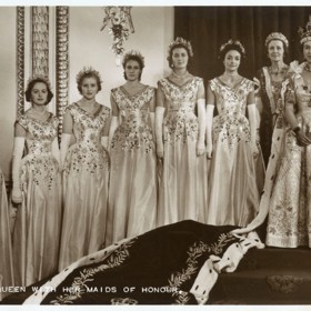 Britská královna Alžběta II. a dvorní dámy, které jí pomáhaly nést vlečku.