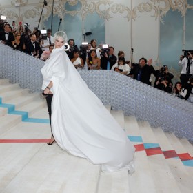 Vlečka, a vůbec celý střih peleríny doplňující minimalistické košilové šaty, nešla přehlédnout. Modelka ji také patřičně "prodala".