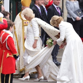 Královna Camilla oblékla bílé šaty se zlatým vyšíváním od oblíbeného návrháře princezny Diany Bruce Oldfielda.