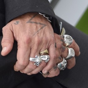 Johnnyho ruce vždy zdobí obří prsteny s lebkami a dalšími symboly. 