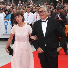 Naprosto ukázkově splněný dress code v roce 2013 Jiří Bartoška podpořil navíc pro něj dnes nepředstavitelnou hladce oholenou tváří. Jeho žena Andrea sáhla po oblíbené midi délce a jednoduchých prořezávaných šatech v pudrově růžové.