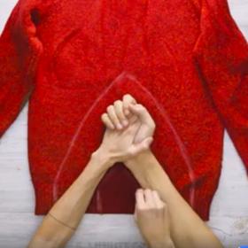 1. Rozložíme svetr na rovnou plochu a obkreslíme na něj spojené ruce. Namalovaný tvar by měl připomínat cirkusový stan nebo iglú.