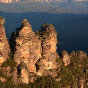 4. Tři sestry, Modré hory, Austrálie. Z výšky zhruba 900 metrů shlíží na magické údolí prorostlé eukalyptovými lesy. Tyto pískovcové výběžky dostaly své jméno po třech sestrách z kmene Katoomba, které se zamilovaly do mužů ze sousedního kmene Nepean. Zákony jejich kmene však takovou svatbu zakazovaly, a tak je nápadníci unesli. Podle aboriginské legendy proměnil stařešina kmene tři sestry v kámen, aby je ochránil. Jenže krátce nato byl zabit. Tři sestry tak přebývají v Modrých horách dodnes.
