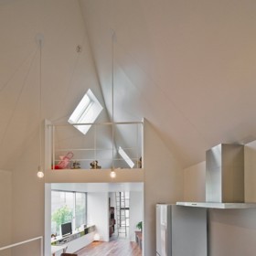 Pro miniaturní plochu, na které dům stojí, vymysleli architekti chytré řešení. Navrhli dvoupatrovou nemovitost, která se směrem nahoru rozšiřuje. V druhém patře tak najdeme rovnou tři místnosti s loftem. Na obrázku pohled z kuchyně do obýváku.