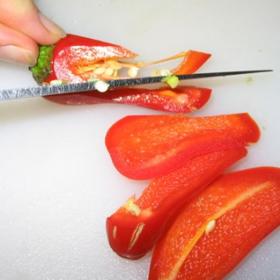 Odřízněte podélně červené části papričky a vydlabejte opatrně semínka.