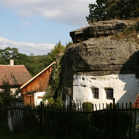 Hospodářství vtěsnané do pískovcového bloku na kraji vsi.
