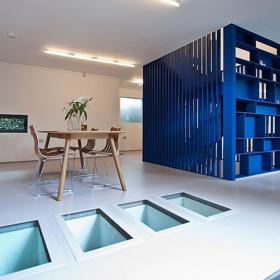 Razantní změny si žádají opulentní rozměry. Futuristické modré schodiště v kombinaci s přírodními materiály v bytě šokuje a prakticky rozděluje velkou místnost na dva samostatné prostory. Autorem tohoto projektu je architekt Rashid Ali.