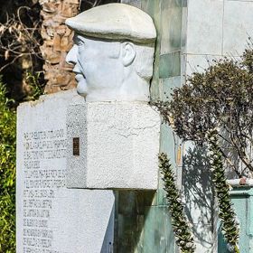 Busta Pabla Nerudy s jeho typickou čapkou.