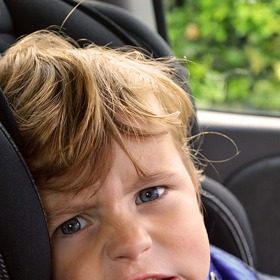 Některé děti nemají jízdu autem rády.