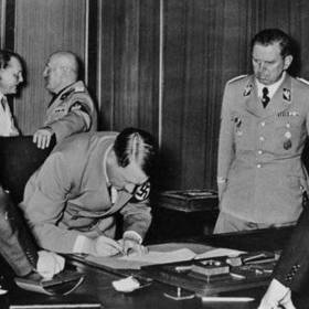 Hitler, Mussolini, Chamberlain, Daladier a další při aktu podpisu tzv. mnichovského diktátu, zatímco členové československé delegace potupně čekali v předsálí.