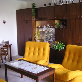 Takový klasický obývák se socialistickou sedačkou a stěnou