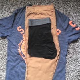 Jako první si nachystejte tričko. Rozložte ho, dejte na něj kalhoty a podélně je přehnete. Přidejte spodní prádlo (rovněž svisle přehnuté).