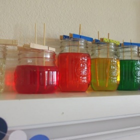 ​5. Cukrové krystaly. Nasypte pár lžiček cukru do sklenice naplněné ze čtvrtiny vodou. Posypte kus papíru cukrem. Vezměte špejle na ražniči, ponořte je do směsi a míchejte. Až se kousky cukru na špejle přichytí, vytáhněte je a položte na papír. Nechte přes noc vyschnout...