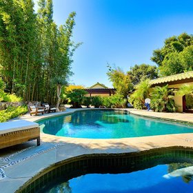 Bazén je obklopen zelení.