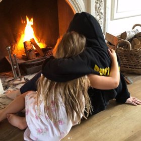 Rodina si v obývacím pokoji užívá u krbu.