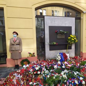 Pietní místo zdobí krásné věnce, květiny a svíčky.