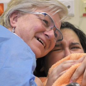 Elišce je při porodu oporou její adoptivní maminka Marie.