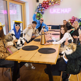 Účastníci reality show u velkého stolu.