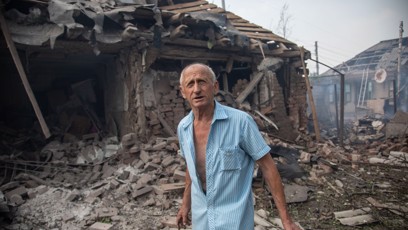 FOTO: Muž před vybombardovanými budovami ve Slavjansku.