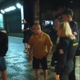 Muž v oranžové košili se snažil situaci klidnit.