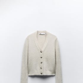 Perfektně je doladí propínací svetřík mohérového vzhledu s přiznanou zvířecí srstí lamy alpaky. (Zara, 999 Kč)