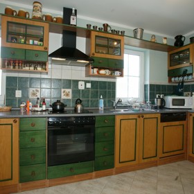 Milan Drobný a jeho kuchyň s dřevěným obložením. Nechybí půllitry pro štěstí.