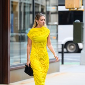 Zářivě žlutý model Gigi Hadid taktéž částečně odhalil negliže, materiál řasených midi šatů totiž také decentně prosvítal.
