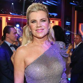 Model s odhaleným ramenem zpěvačka doladila sčesanými vlasy a decentní sadou šperků.