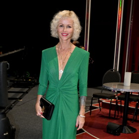 Spisovatelka Karin Babinská oblékla výraznou zelenou róbu s dlouhým rukávem, kterou doplnila černým psaníčkem značky Yves Saint Laurent.