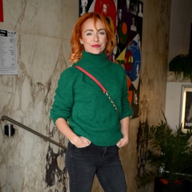 Čerstvá rusovláska doladila lahvově zelený svetřík černými džínami.