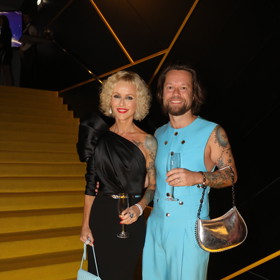 Zpěvák Richard Krajčo na sebe upozornil v tyrkysovém obleku s dámskou kabelkou. Jeho žena Karin jej doplnila pro změnu tyrkysovou kabelkou.