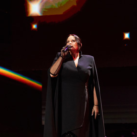 Asymetrická délka a rukávy propojené v impozantní pelerínu. Jitka Čvančarová na pódiu zazářila nejen svým hlasovým projevem.