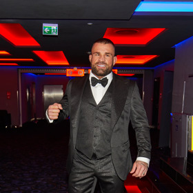 Hlavní hvězda dokumentu, bijec Karlos Vémola, vynesl tmavě šedý oblek ze třpytivého materiálu. Nechybí mu vestička, manžetové knoflíčky ani motýlek.