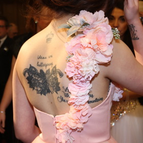 Zezadu, při pohledu na její potetovaná záda, se vytratilo veškeré kouzlo jejích romantických šatů.