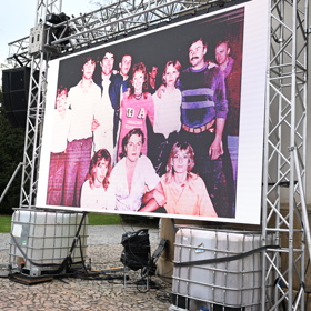 Na plátně se promítají fotky rodiny. 