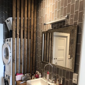 Koupelna Jitky Asterové je vyvedena v teplých barvách, kachlíky doplňuje dřevo.