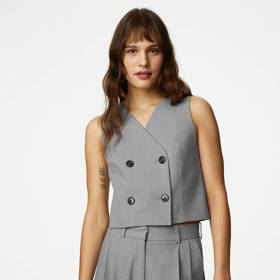 Krátká vesta na holé tělo, ideální pro kombinování s kalhotami z totožného materiálu. (Vesta, MarksSpencer, 1 299 Kč)