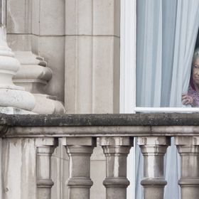 Viz tato fotografie, kdy Alžběta II. v prakticky totožném outfitu jako Charlotte hledí z okna Buckinghamského paláce. (2016)