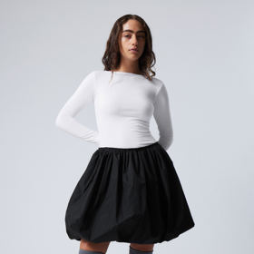 Kratší délky také mohou vyhlížet hezky, zkuste je doladit vyššími podkolenkami i obuví a vznikne velmi hravý outfit. (Weekday, 1 290 Kč)