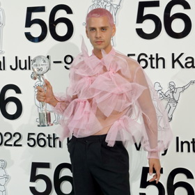 Španělský režisér Eduardo Casanova si v roce 2022 přebíral křišťálovou sošku v růžové volánové halence.