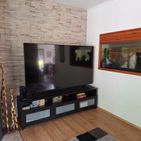 Pod televizí jsou naskládané deskové hry.