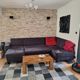 Pohovka proti krbu a televizi, kde Andrea Kalivodová sedává.