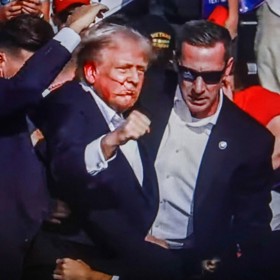 Donald Trump hrdinně pózuje před kamerami po útoku atentátníka v roce 2024.